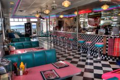 the interior of a diner with checkered flooring and neon lights on the ceiling