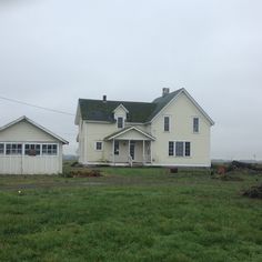 a white house sitting on top of a lush green field