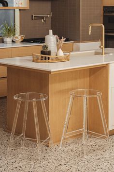 two clear stools sit in front of an island