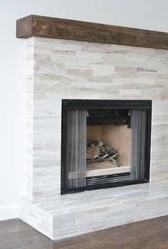 a white fireplace with a wooden mantle in the middle