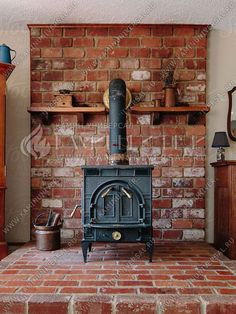 an old fashioned stove in the corner of a living room with brick walls and shelves