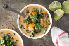 two bowls filled with soup next to limes