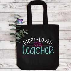 a black tote bag with the words most loved teacher on it