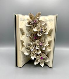 an open book with paper flowers on it