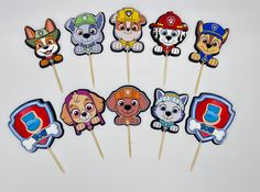 a bunch of cupcake toppers that are on a white table with dogs and fireman's hats