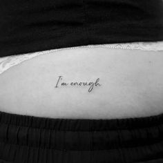 the word i'm enough written on the side of a woman's stomach