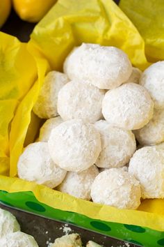 a bag full of snowball cookies sitting on top of a yellow cloth covered table