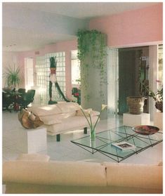 a living room filled with lots of furniture next to a tall white plant in the corner