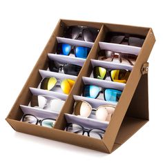 an open cardboard display case with several pairs of sunglasses in it on a white background