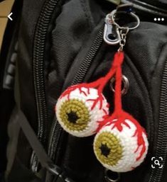 two crocheted eyeballs hanging from a backpack