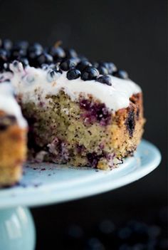 a blueberry cake on a plate with one slice cut out