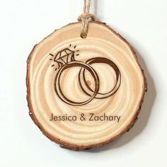 a wooden ornament with two wedding rings on it