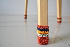 a pair of wooden legs with multicolored knitted socks on them sitting next to each other