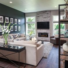 a living room filled with furniture and a flat screen tv mounted on the wall above a fireplace