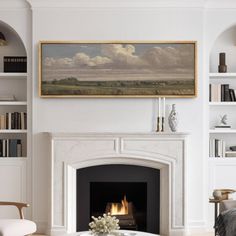 a living room filled with furniture and a fire place in front of a painting on the wall