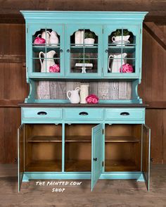 an old china cabinet painted in blue with pink flowers on the top and bottom shelf