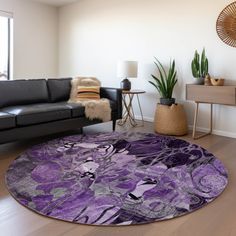 a living room with black leather couches and a purple area rug on the floor