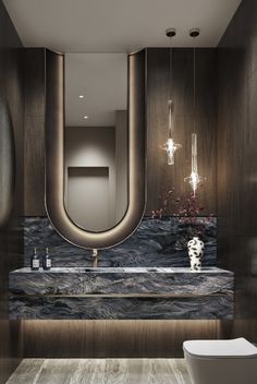 a modern bathroom with marble counter tops and dark wood cabinets