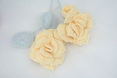 three crocheted flowers on a white surface