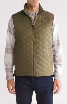 Whether you're deep in the backcountry or just your own backyard, you'll appreciate the cozy core warmth of this vest filled with  polyester insulation. 26 1/2" length (size Medium) Front zip closure Stand collar Front welt pockets Lined, with 100% polyester fill 100% nylon Machine wash, tumble dry Made in China Sleeveless Vest With Fleece Lining For Outdoor Activities, Khaki Sleeveless Nylon Vest, Green Winter Vest For Outdoor Activities, Khaki Outdoor Vest For Fall, Khaki Vest For Outdoor Winter Activities, Khaki Outdoor Vest, Khaki Nylon Vest, Quilted Sleeveless Winter Vest, Casual Khaki Outerwear For Camping