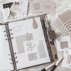 the contents of a planner spread out on top of a white table with pens and markers