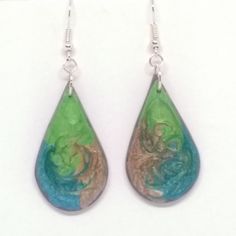 These earrings are made from polymer clay shapes, painted and resin glazed giving a rounded highly polished appearance.  The paint has a fascinating appearance, catching the light and giving a 3 dimensional effect.  The earrings are 3cm diameter.   The earrings have nickel free fish hook fastenings and the back of the earrings are plain coloured as shown. Unique Green Teardrop Earrings For Gift, Green Resin Drop Earrings, Green Enamel Earrings With Artistic Design, Handmade Resin Teardrop Earrings As Gift, Unique Iridescent Teardrop Earrings, Green Hand-painted Polymer Clay Earrings, Green Hand Painted Polymer Clay Earrings, Hand Painted Green Earrings In Polymer Clay, Hand Painted Green Polymer Clay Earrings