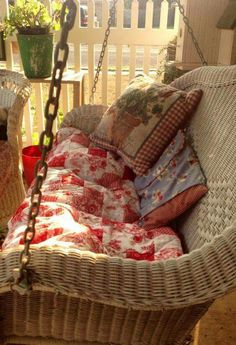 a wicker hanging chair with pillows on it