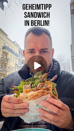 a man eating a large sandwich in berlin with the caption'geheimtpp sandwih in berlin '