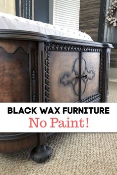 a black wax furniture with no paint on the top and bottom, in front of a bed