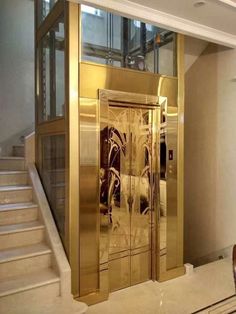 an elevator with glass doors and marble steps