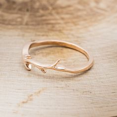 a close up of a gold ring on a wooden surface