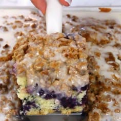 a close up of a cake in a pan with blueberries and cream on top