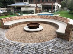 an outdoor fire pit surrounded by bricks and gravel