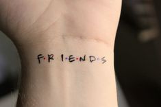 the word friends written in small black letters on someone's left wrist and arm