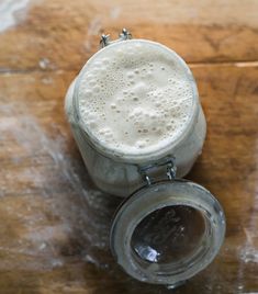 a glass filled with liquid sitting on top of a wooden table