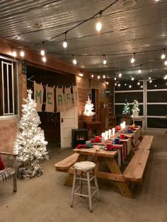 a long table with christmas decorations on it and lights hanging from the ceiling in an indoor space