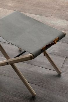 a small wooden folding chair sitting on top of a hard wood floor