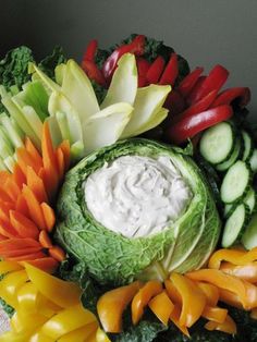 an arrangement of vegetables with dip in the center and on top, all arranged together