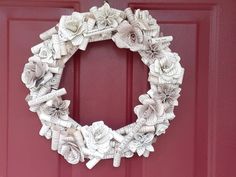 a wreath made out of books is hanging on the front door's red door