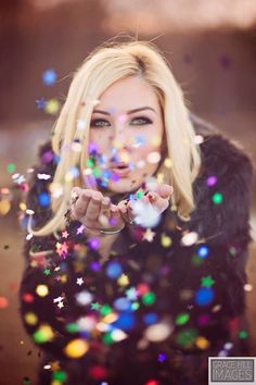 a woman with blonde hair and blue eyes is surrounded by colorful bubbles in the air