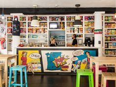 the interior of a comic themed restaurant with colorful stools and artwork on the walls