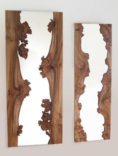 two wooden mirrors sitting next to each other on top of a white wall and one is made out of wood