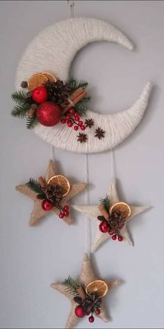 three star and moon decorations hanging from the ceiling in front of a white wall with red ornaments