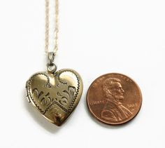 Vintage Heart Locket Necklace. This gold filled locket has decorative engravings and the letter P at the bottom. On the back, it is engraved with the date 8-19-5. Inside the locket contains one metal frame. The locket opens and closes easily and securely. The new gold filled chain was added by me, not vintage. Circa 1950's No hallmarks Measurements- Chain is 18 inches in length Locket is about 1 inch length Very good condition. Minor wear due to age and use. Victorian Brass Necklace With Heart Charm, Vintage Heart-shaped Brass Jewelry, Collectible Medallion Jewelry For Valentine's Day, Vintage Brass Heart-shaped Jewelry, Antique Brass Jewelry With Heart Charm, Vintage Brass Heart Shaped Jewelry, Antique Hallmark Jewelry For Valentine's Day, Vintage Heart Charm Medallion Jewelry, Antique Heart-shaped Jewelry With Hallmark