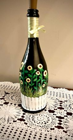 a black and white vase sitting on top of a table next to a doily