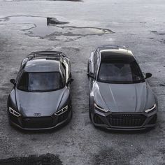 two cars parked next to each other in a parking lot with no one around them