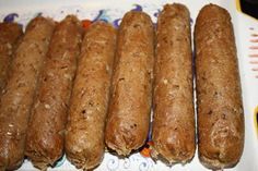 five long sausages sitting on top of a white plate