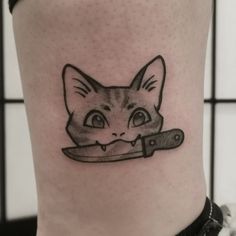 a cat with a knife tattoo on its leg