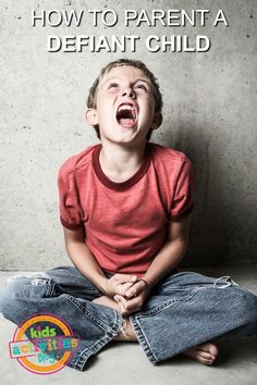 a young boy sitting on the floor with his mouth open