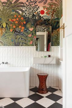 a bath room with a large mural on the wall and a white tub in front of it